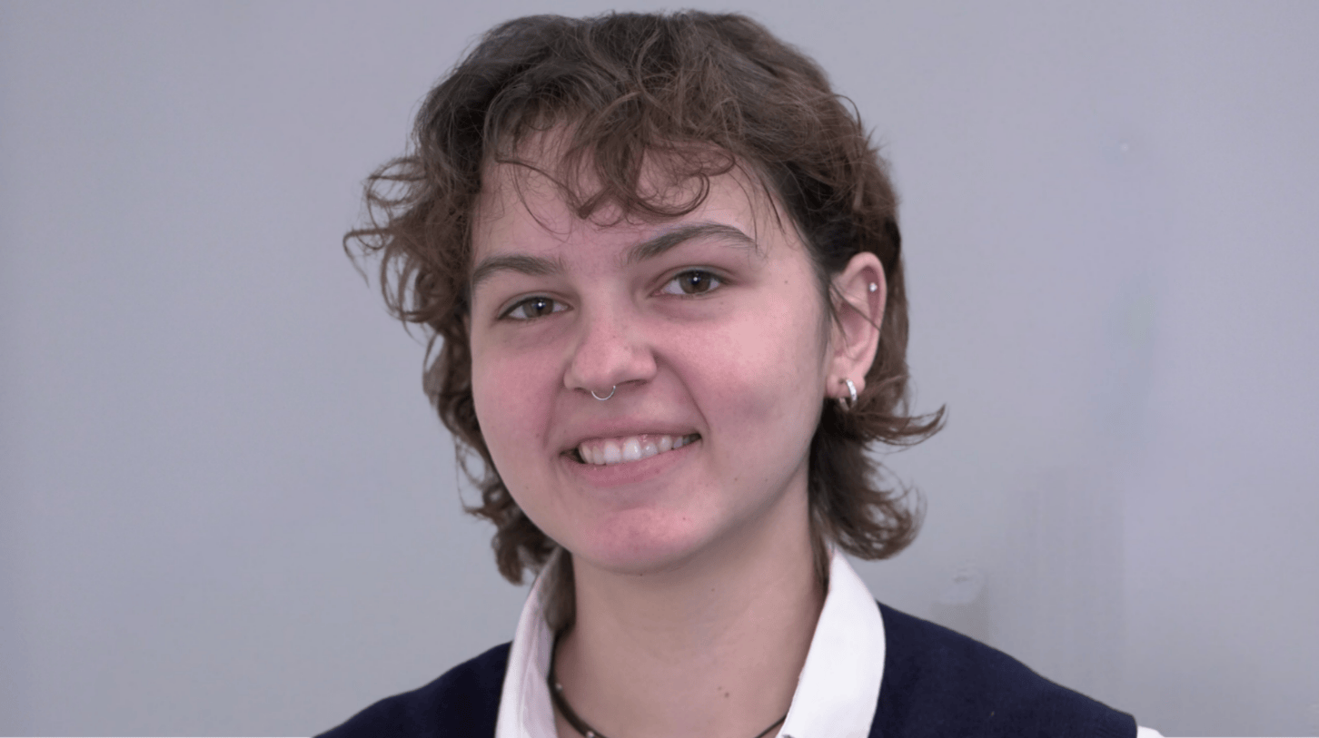 Portrait of Loyola University Chicago student smiling against gray background